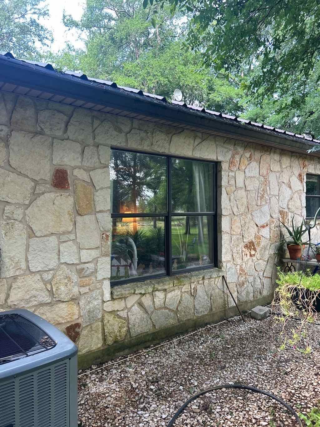 Anlin Panoramic window with Architectural Bronze Thermatrue frame on stone Hill Country home in Dripping Springs TX by Glacier Home Exteriors