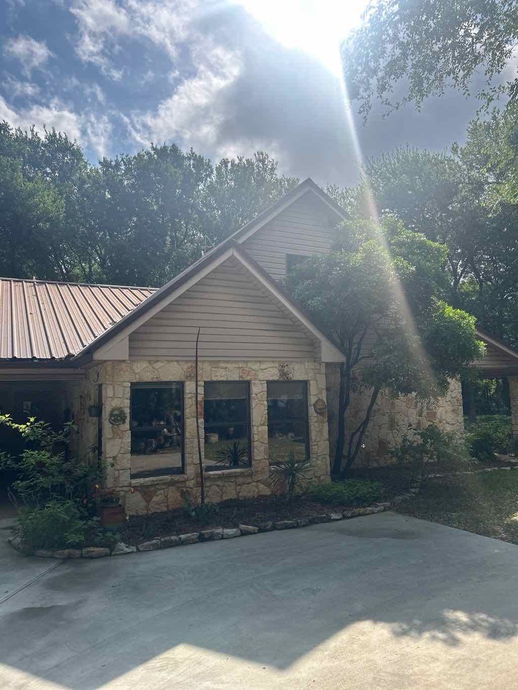Anlin Panoramic windows in Architectural Bronze on stone Hill Country home full front elevation Dripping Springs TX by Glacier Home Exteriors