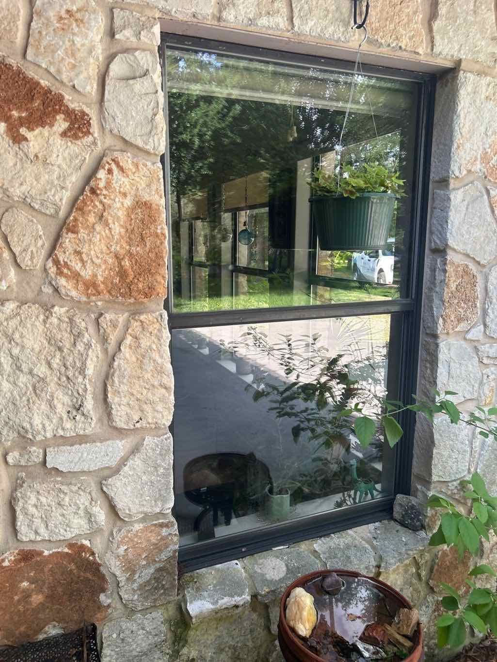 Anlin Panoramic Arch window black frame on natural stone masonry home in Georgetown TX by Glacier Home Exteriors